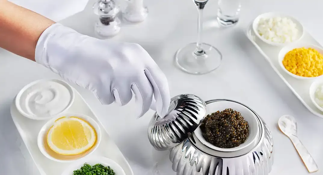 Caviar served by a gloved hand in Emirates First Class