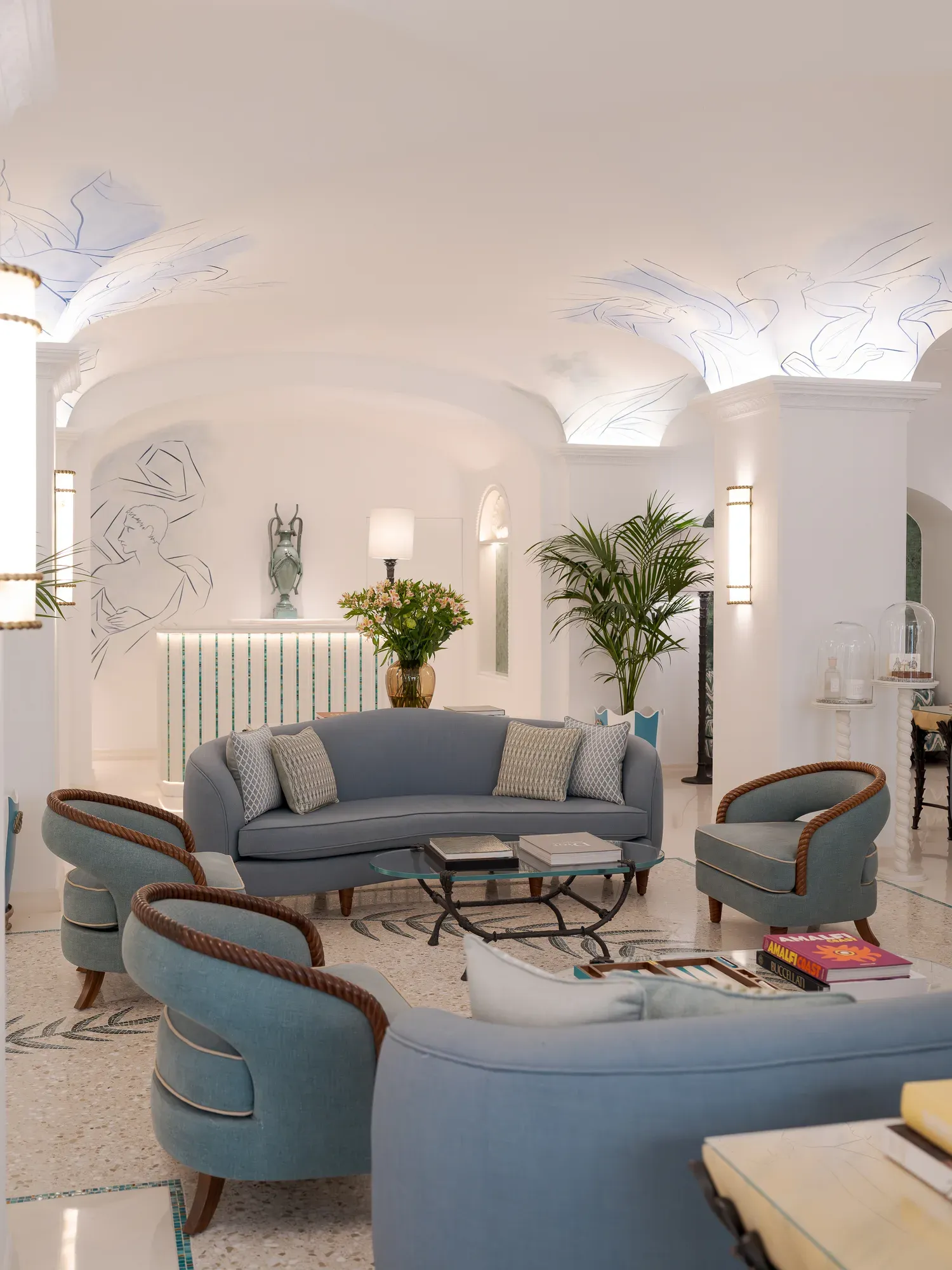 The lobby of Hotel La Palma with blue sofas under a vaulted white ceiling