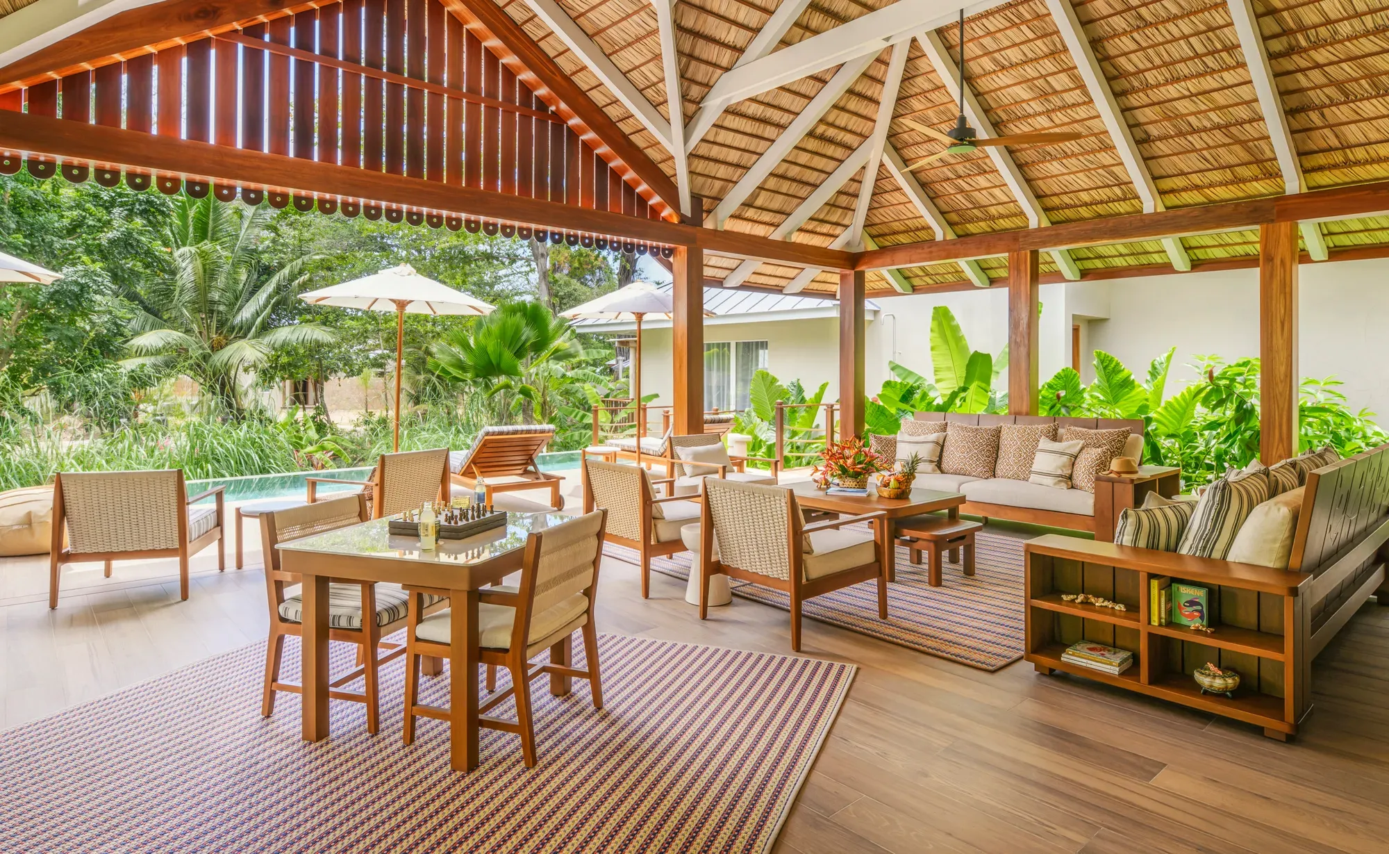 The veranda of a villa at La Réserve Seychelles, open to the garden and the pool