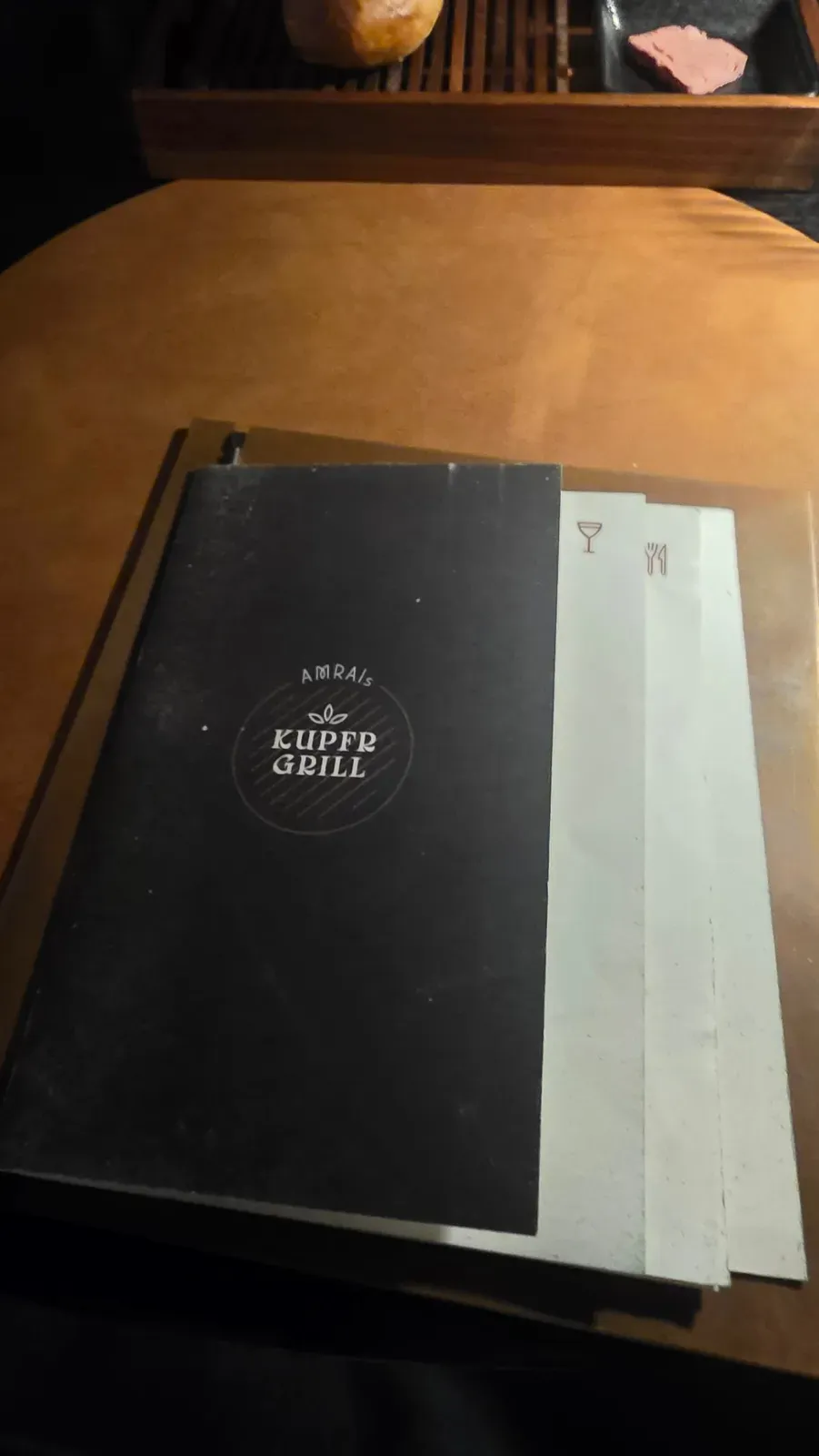 The menu of AMRAI's Kupfrgrill on the table in Schruns