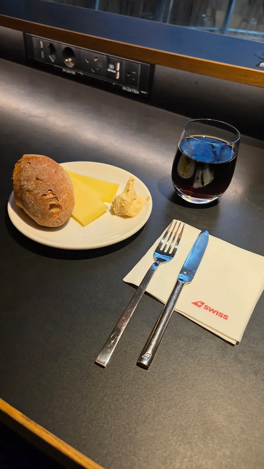 A bread roll, Swiss cheese and hummus with a Coke in the SWISS Business Lounge at Zurich Airport, Terminal A