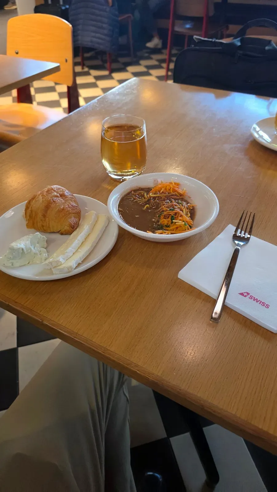 A croissant with cheese and herb quark and a bowl of soup in the SWISS Senator Lounge