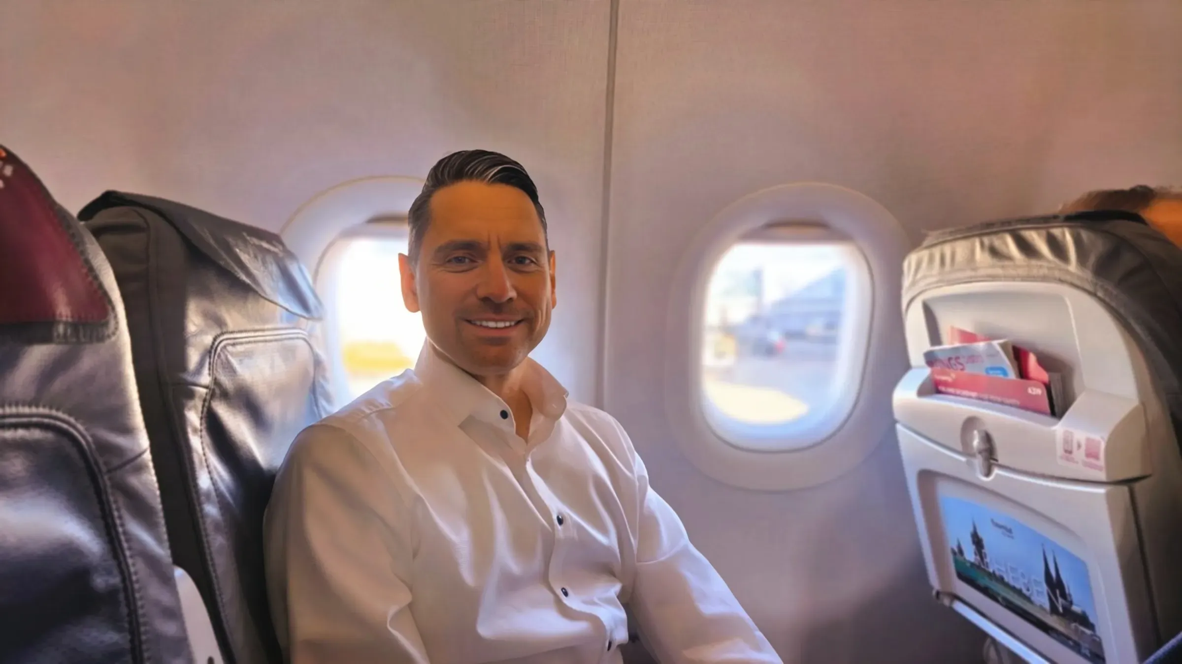 Roger Hohl smiling in his window seat in Eurowings Biz-Class on the Airbus A319 from Zurich to Hamburg