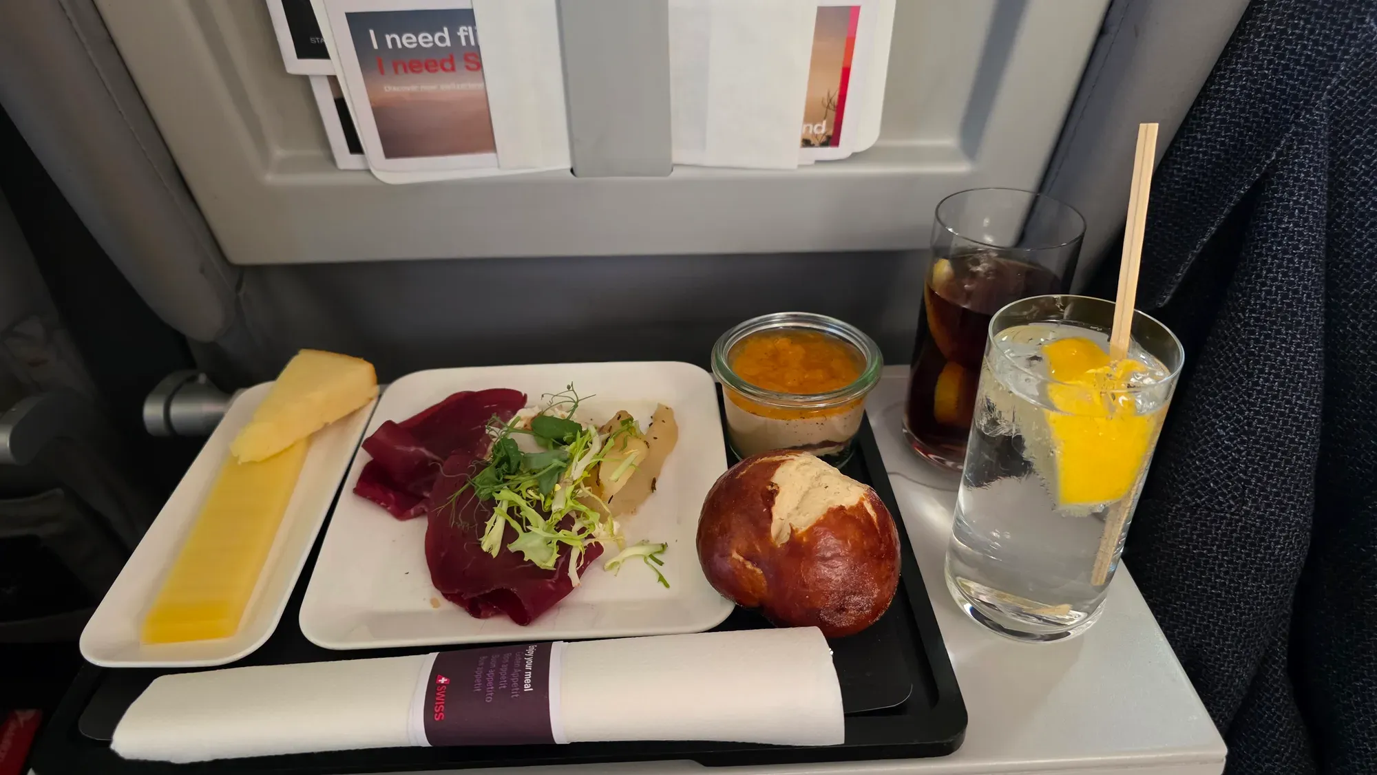 SWISS Business Class meal on the Helvetic E195-E2 with Bündnerfleisch, Swiss cheese, a pretzel roll, a dessert in a jar and drinks