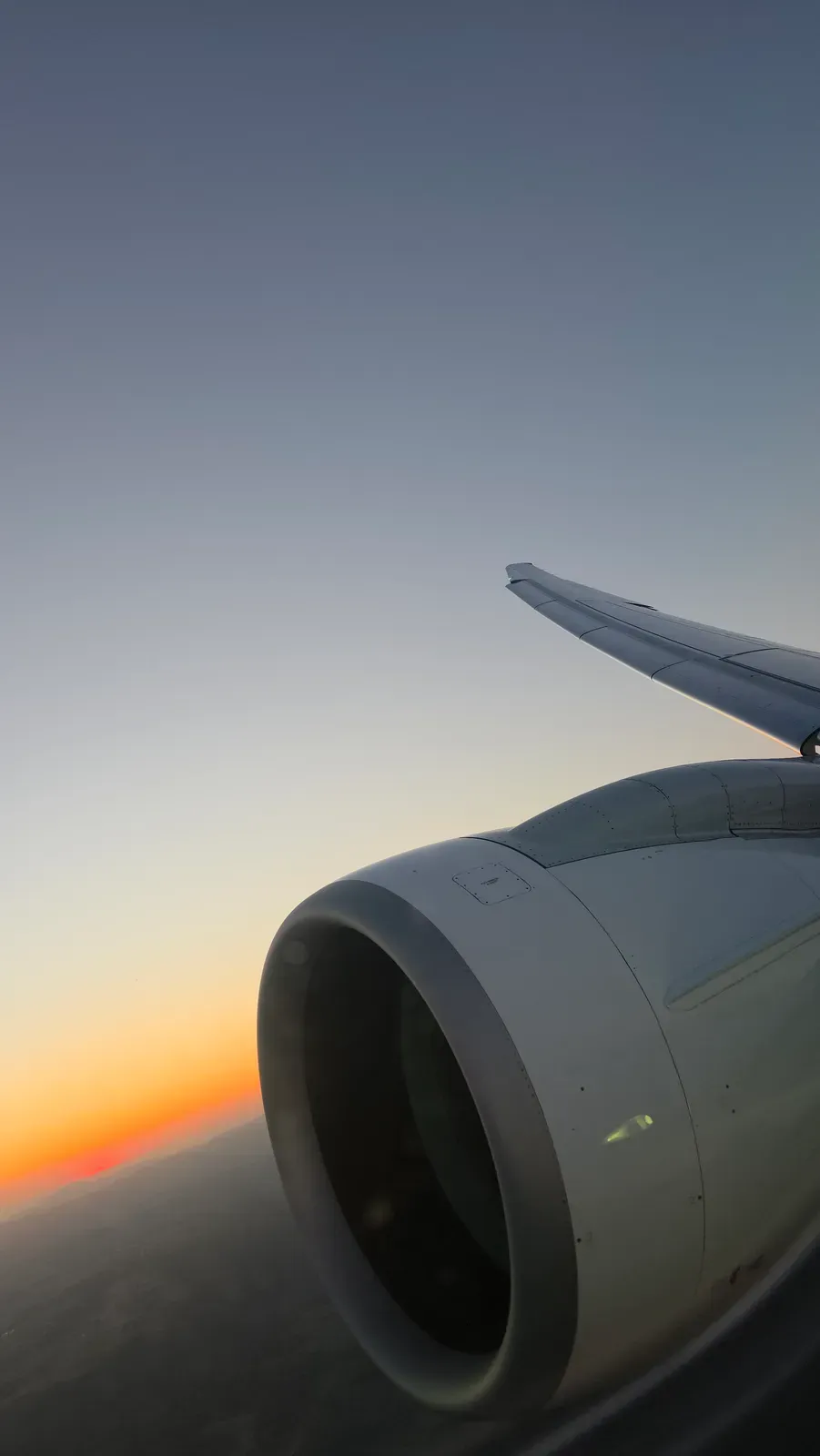 The sun setting below the engine of the Helvetic E195-E2 on the descent towards Zurich
