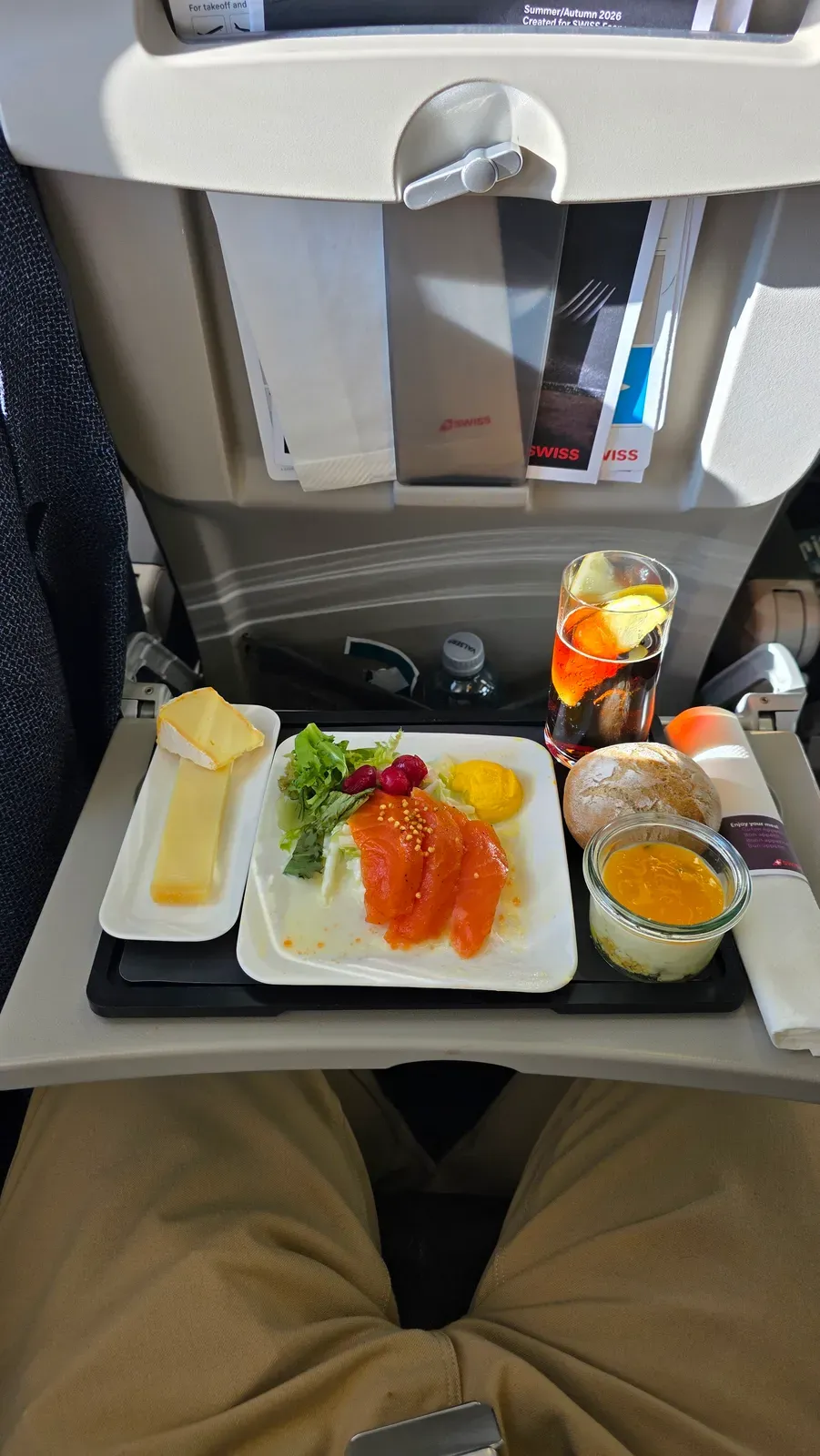 The SWISS Business Class meal tray seen from the seat, with the Summer/Autumn 2026 card in the seat pocket