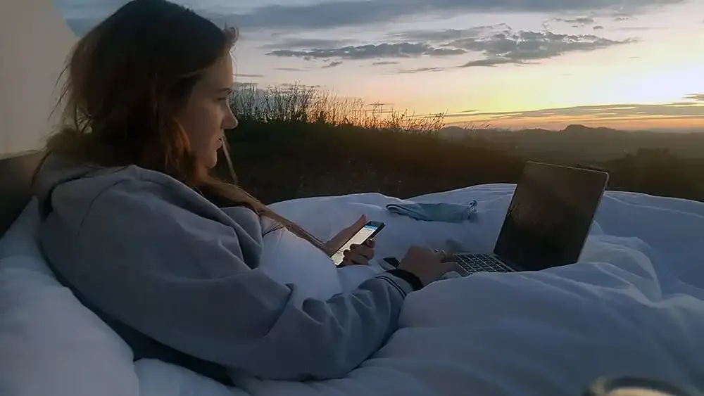 Guest watching a film on a laptop in the Null Stern bed