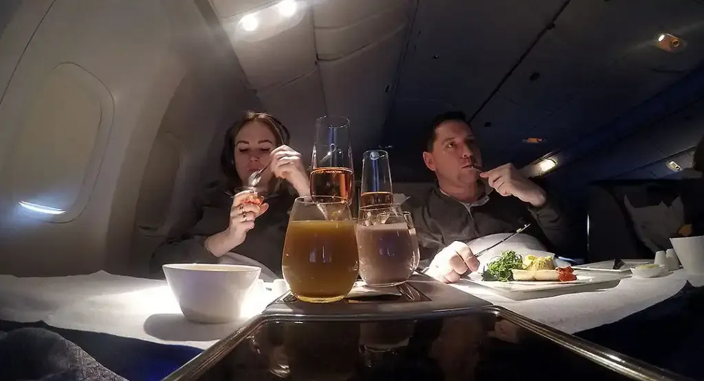 Passengers dining in Qatar Airways Boeing 777-200LR Business Class