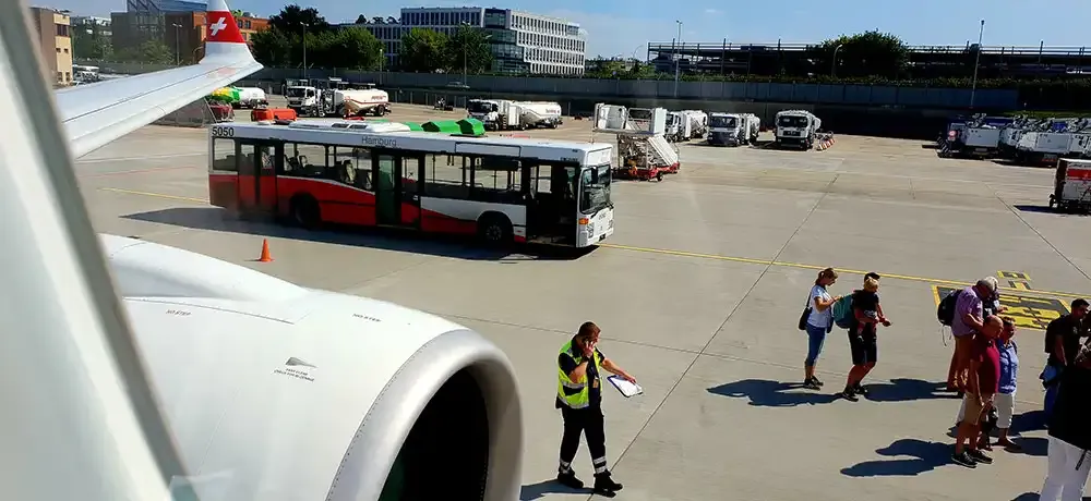 Passengers boarding the SWISS A220-300 from the apron bus